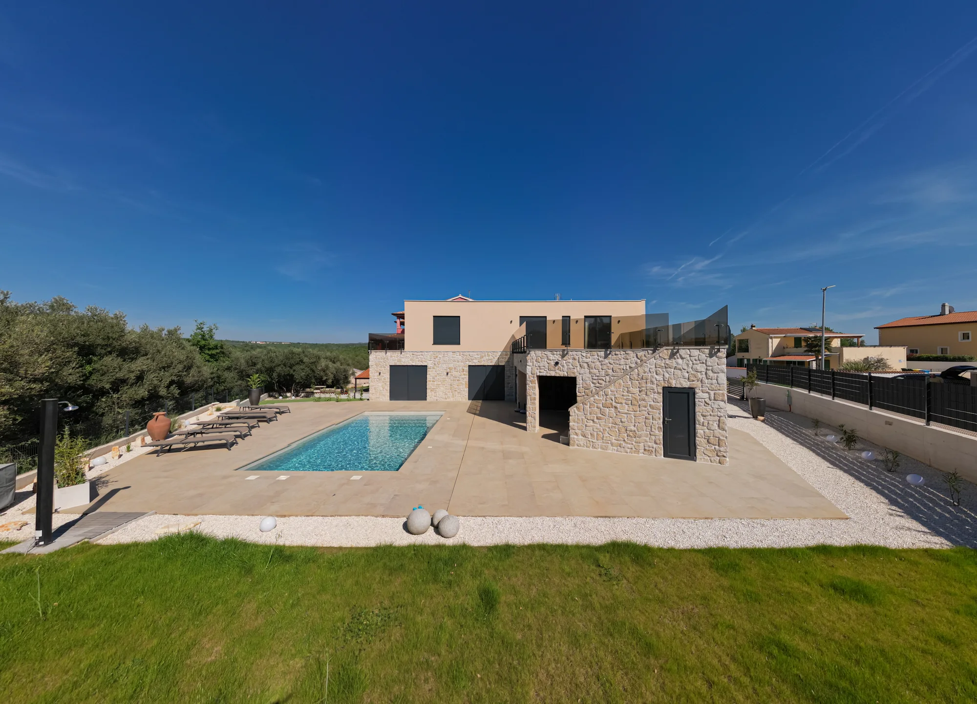 Designhaus mit Pool – Gartenansicht mit Rasen und großzügiger Terrasse
